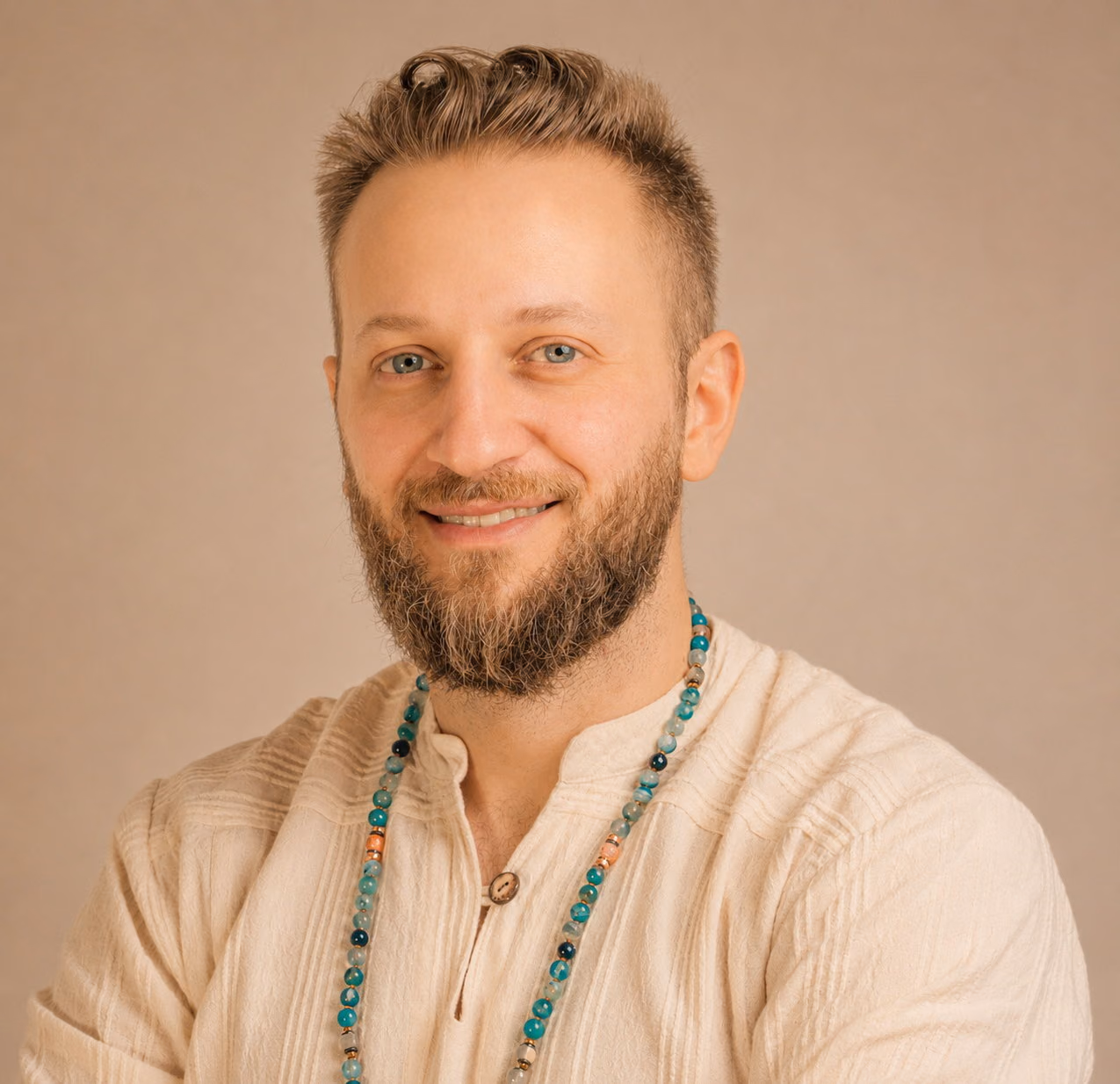 Porträt von Riccardo Di Pasquale, Ayurveda-Komplementärtherapeut in Zürich, in Leinenhemd vor warmem Hintergrund.
